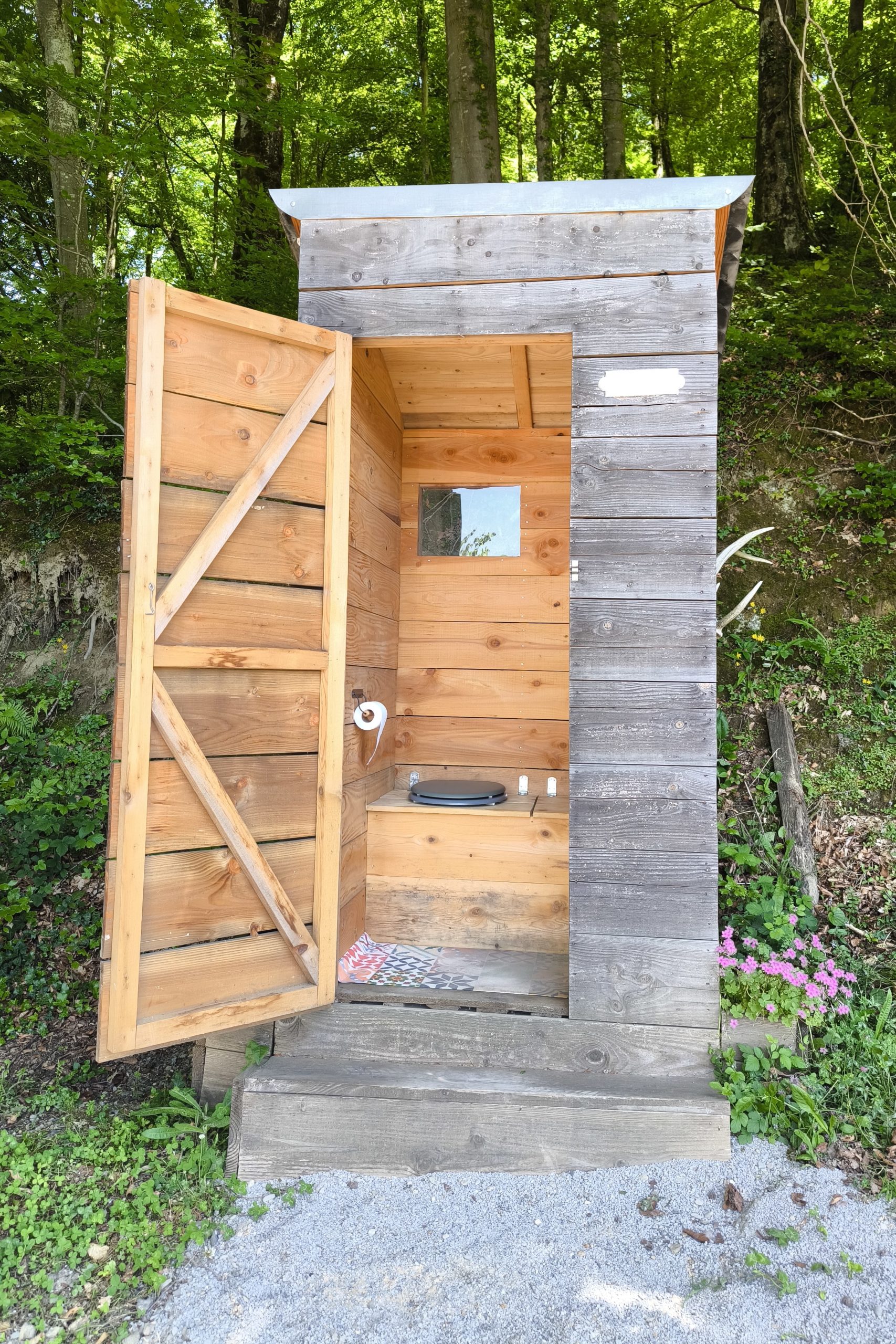 IMG_20250528_144958bis Cabane en bois rustique, ouverte sur la nature, avec un intérieur simple et accueillant.