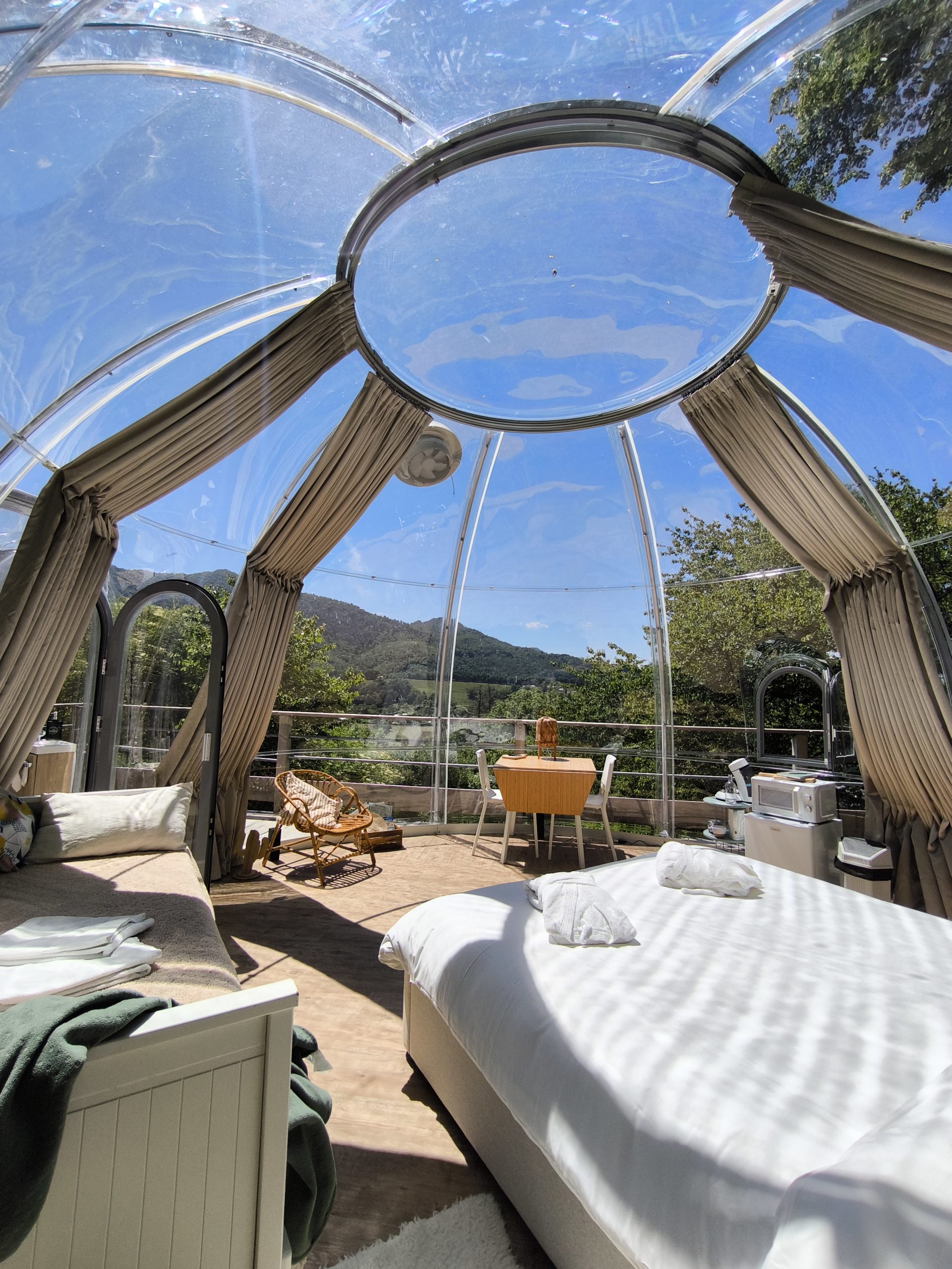 IMG_20250528_145305 Dôme transparent avec vue panoramique sur la nature, lit confortable et coin repas.
