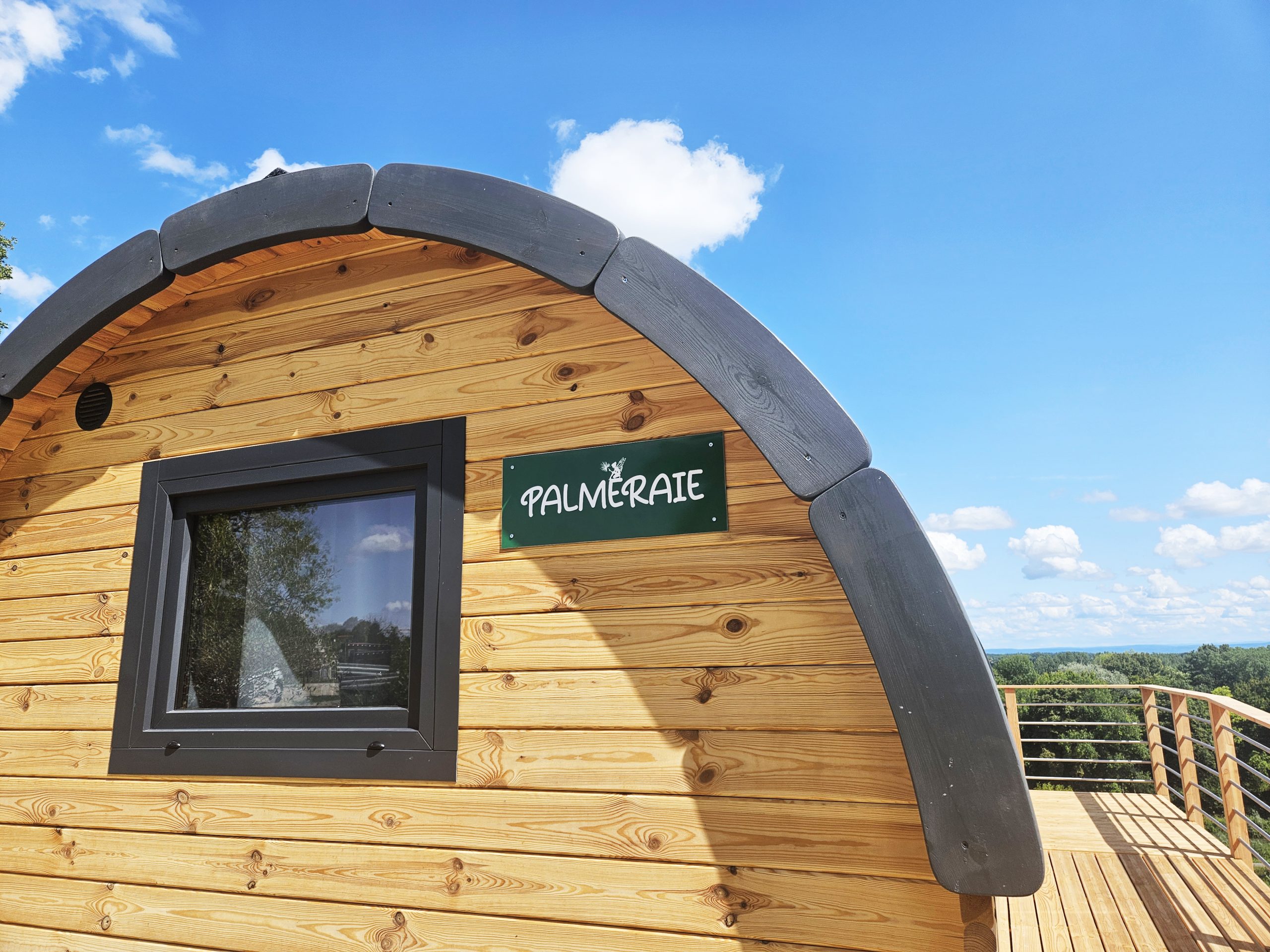 exterieur-palmeraie Cabane en bois "Palmeraie" avec vue dégagée sur la nature et ciel bleu.