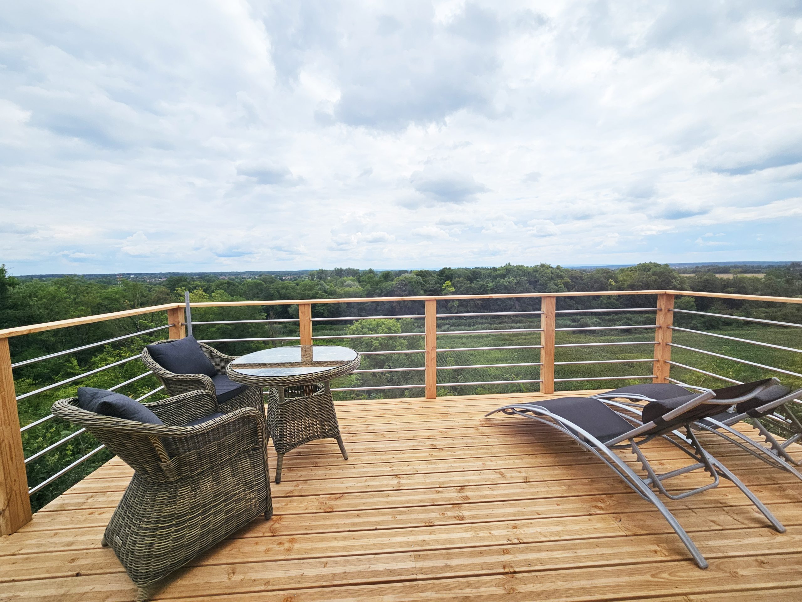 terrasse-palmeraie Terrasse en bois d'une cabane perchée, avec vue panoramique sur la nature environnante.