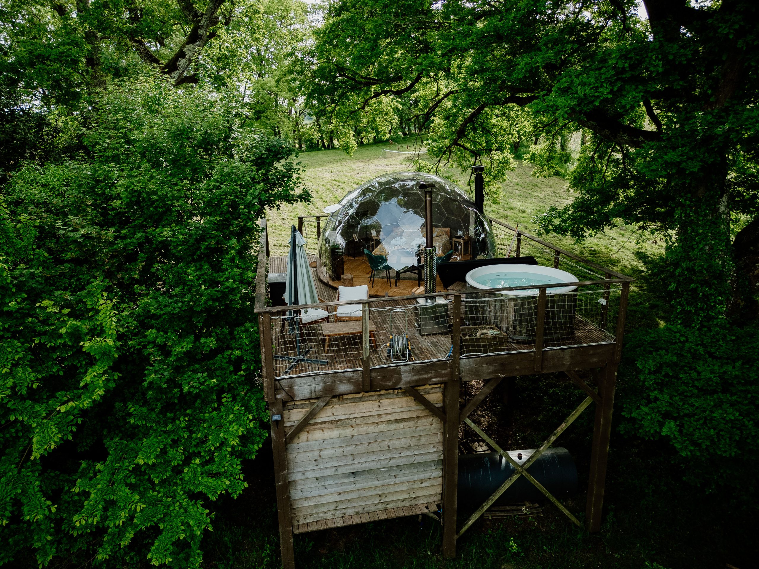 Nuit insolite_bulle_dôme_perché_occitanie_gers_Lartigue_weekend_étoiles_bain_nordique (122) Dôme transparent perché dans les arbres, avec jacuzzi et vue sur la nature environnante.