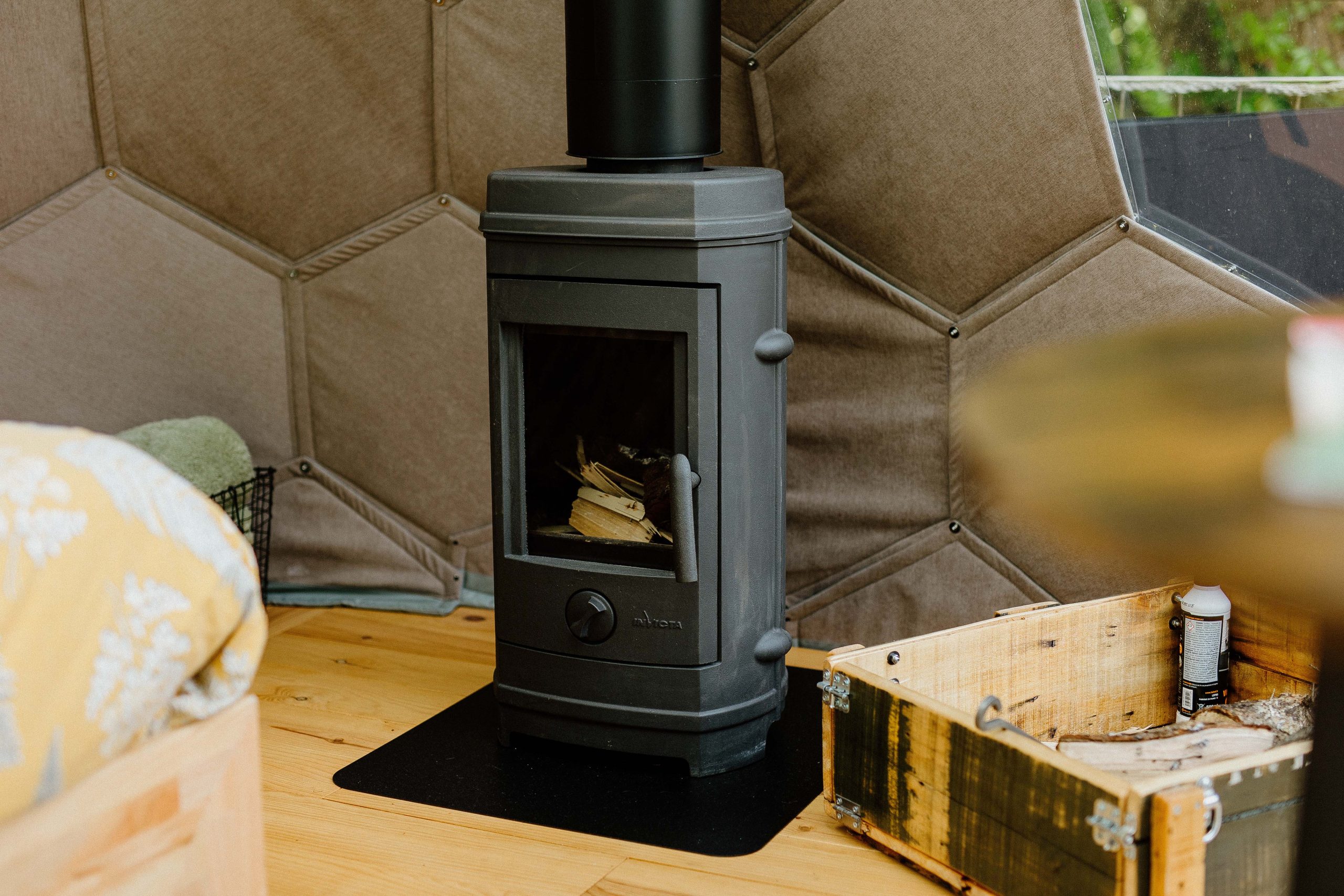 Nuit insolite_bulle_dôme_perché_occitanie_gers_Lartigue_weekend_étoiles_bain_nordique (58) Intérieur d'une yourte avec poêle à bois, ambiance chaleureuse et cocooning.
