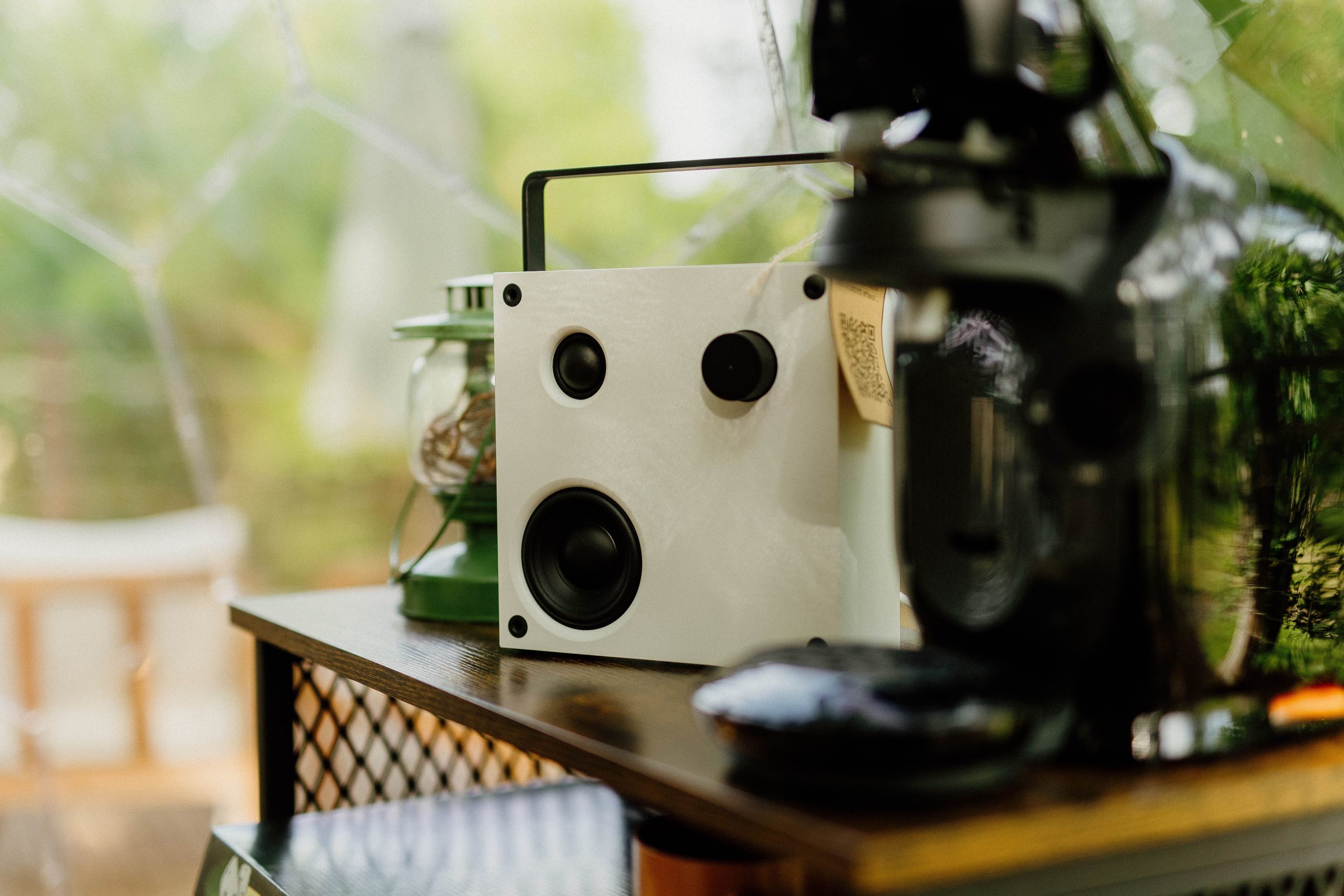 Nuit insolite_bulle_dôme_perché_occitanie_gers_Lartigue_weekend_étoiles_bain_nordique (63) Un hébergement insolite avec un coin café cosy, décoré d'enceintes modernes et d'une lampe vintage.