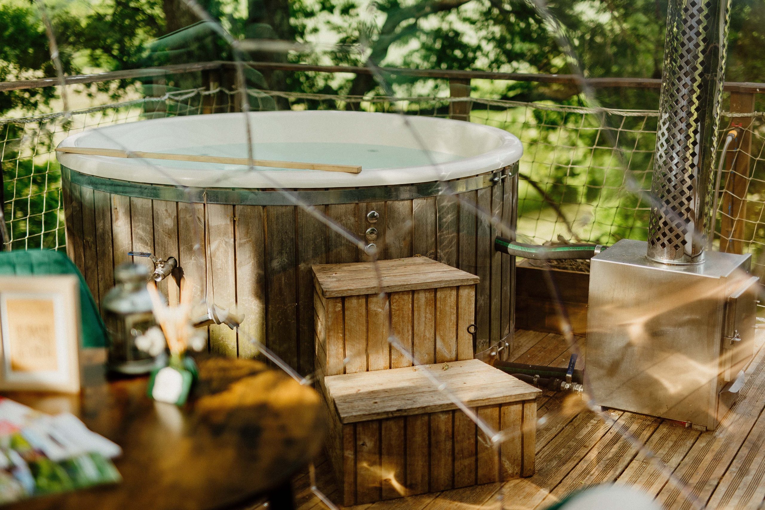Nuit insolite_bulle_dôme_perché_occitanie_gers_Lartigue_weekend_étoiles_bain_nordique (65) Bain nordique en bois sur une terrasse, entouré de verdure, idéal pour se détendre.