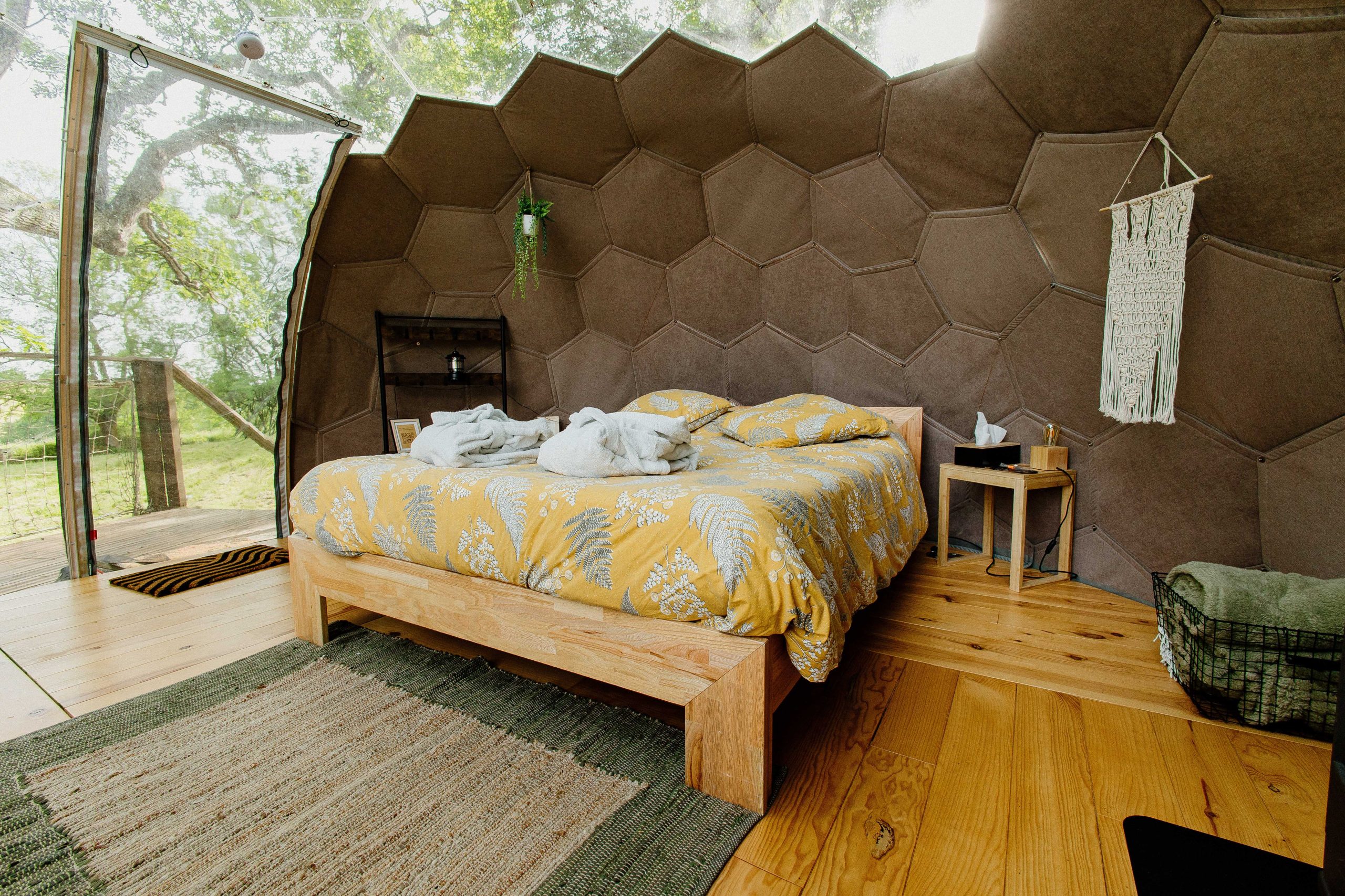 Nuit insolite_bulle_dôme_perché_occitanie_gers_Lartigue_weekend_étoiles_bain_nordique (67) Chambre dans une cabane hexagonale, avec un lit douillet et des murs en bois naturel.