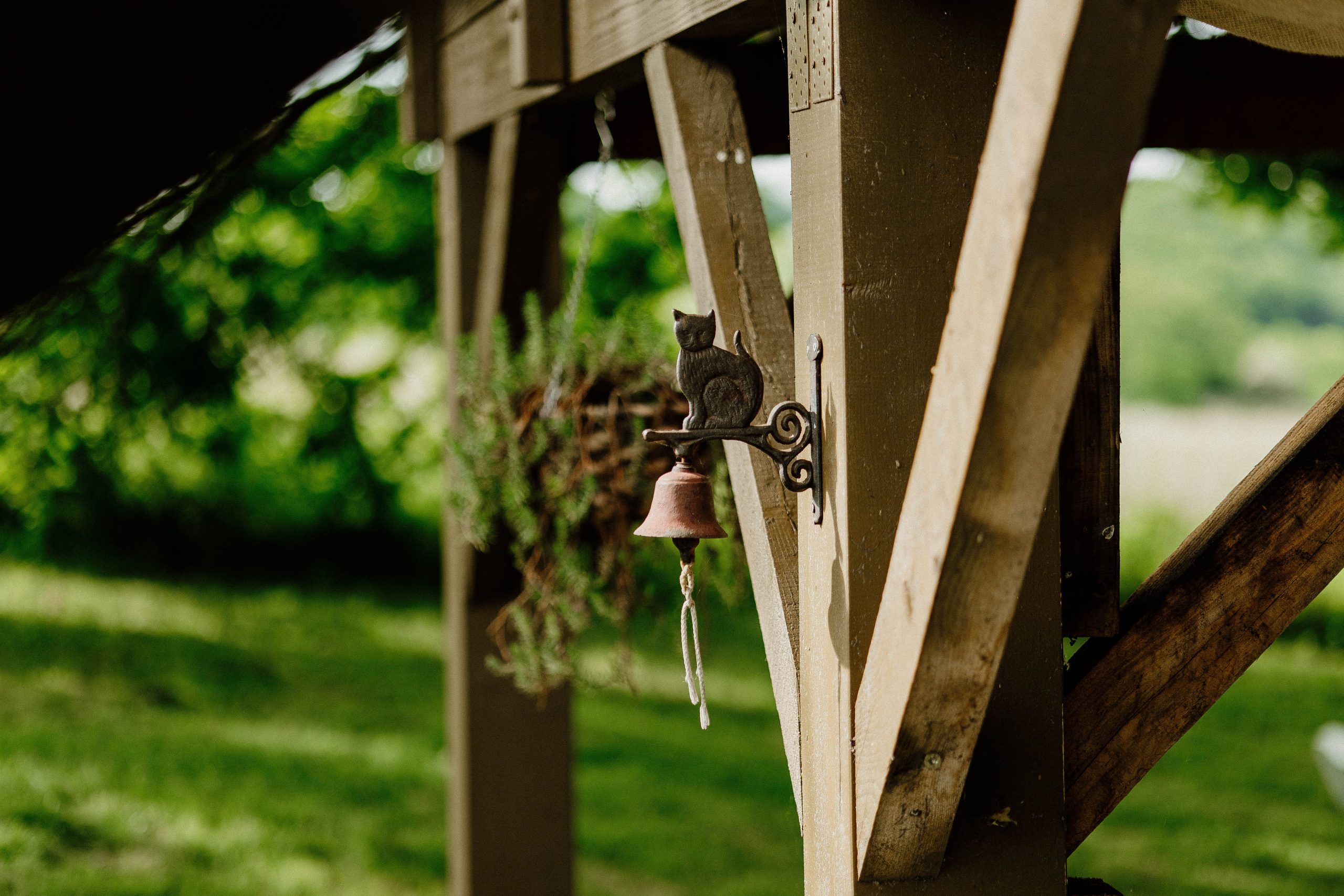 Nuit insolite_bulle_dôme_perché_occitanie_gers_Lartigue_weekend_étoiles_bain_nordique (92) Charmant abri de jardin en bois avec une cloche et une décoration féline, entouré de verdure.
