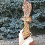 Sculpture en bois représentant un aigle, idéale pour un hébergement insolite en pleine nature.