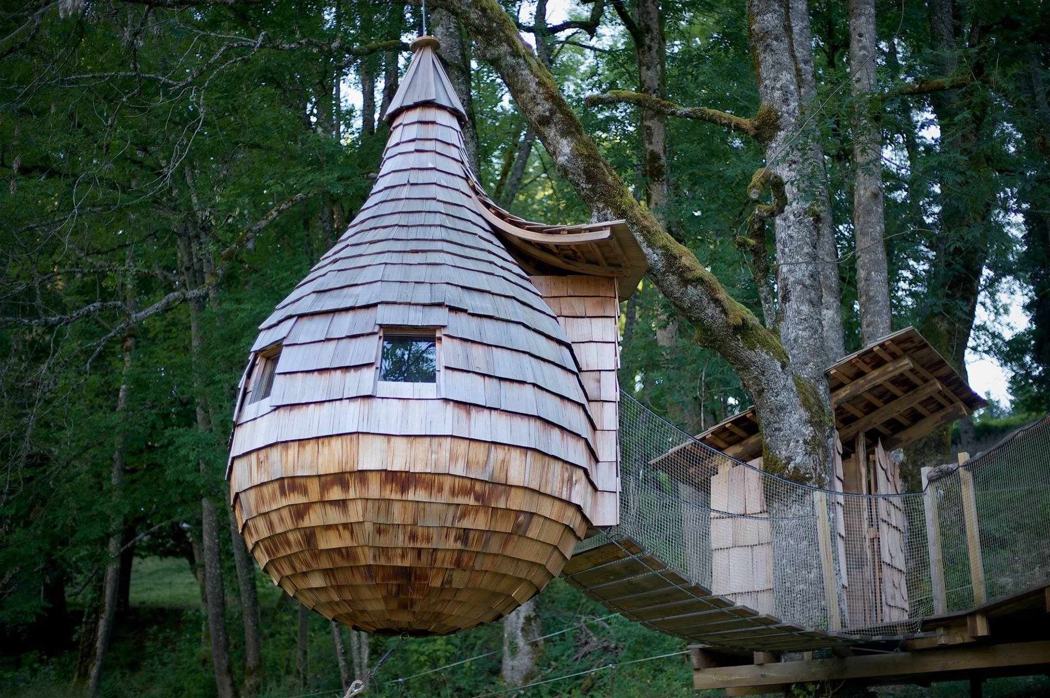 Cabane dans les arbres en bois, suspendue entre les arbres, offrant une vue imprenable.