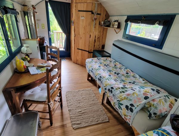 Tiny house chaleureuse avec un intérieur en bois et un coin repas accueillant.