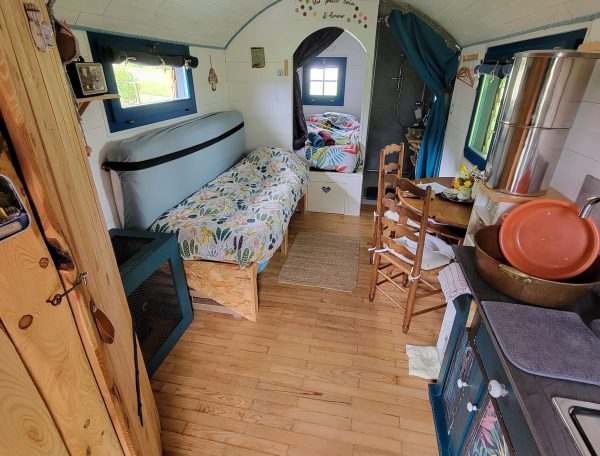 Tiny house chaleureuse avec lit douillet et décor coloré, ambiance cosy.