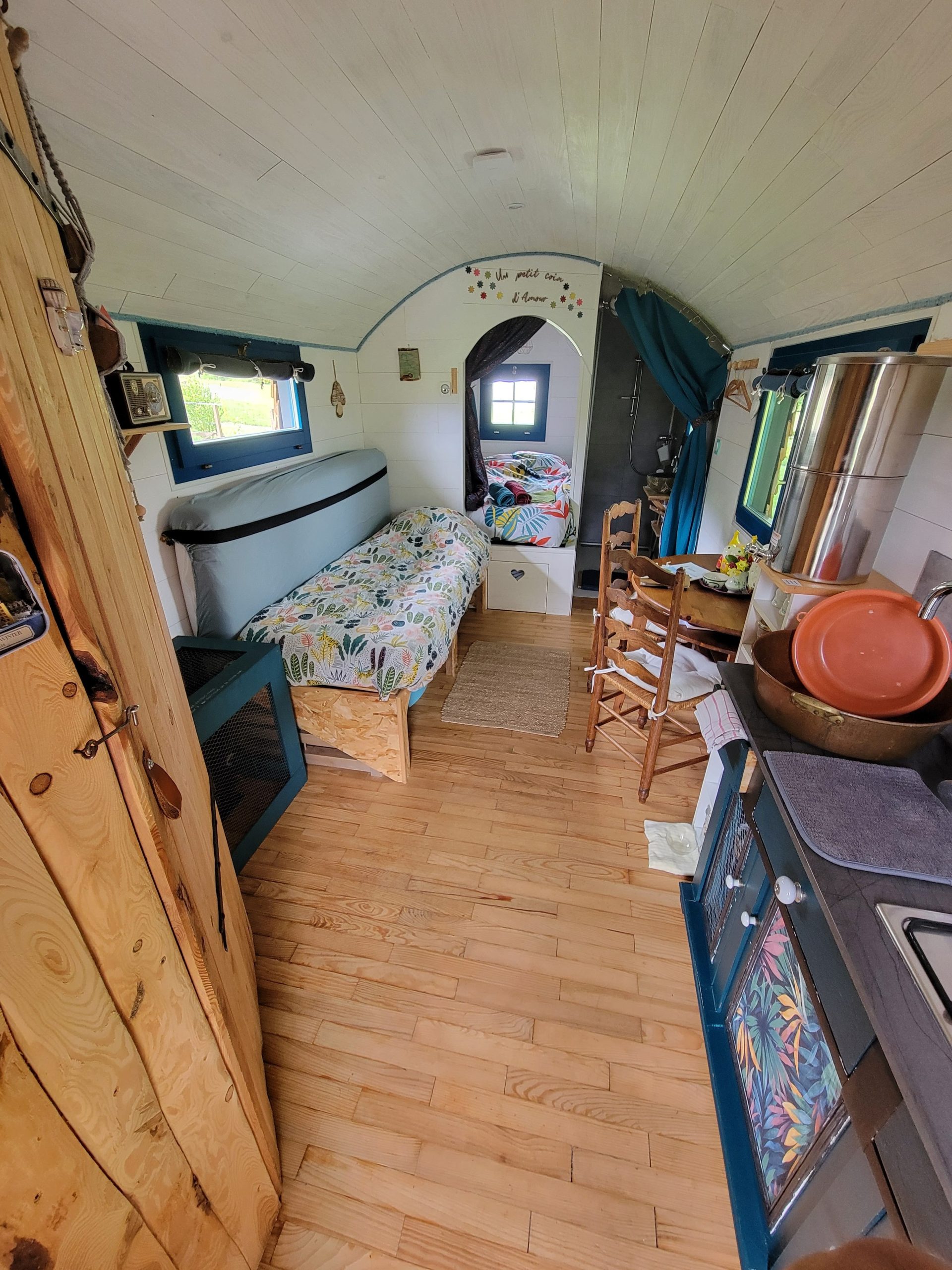 1747308417919 Intérieur d'une tiny house colorée, avec lit douillet et cuisine fonctionnelle. Ambiance