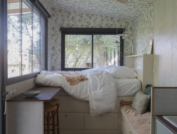 Chambre cosy en bois avec lit surélevé et vue sur la nature. Parfait pour un séjour relaxant.