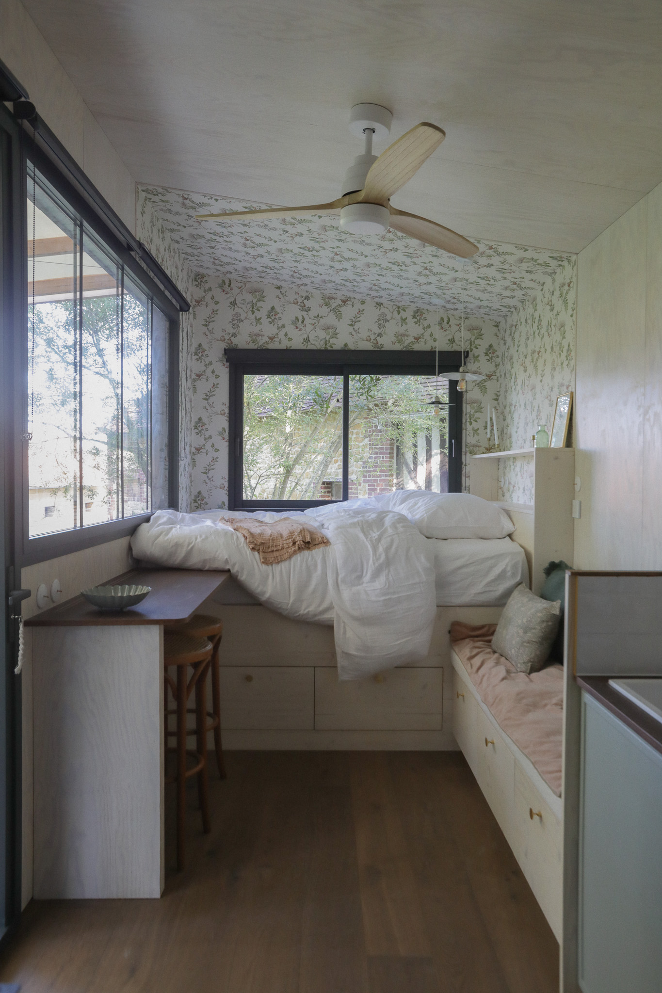 Chambre cosy en bois avec lit surélevé et vue sur la nature. Parfait pour un séjour relaxant.