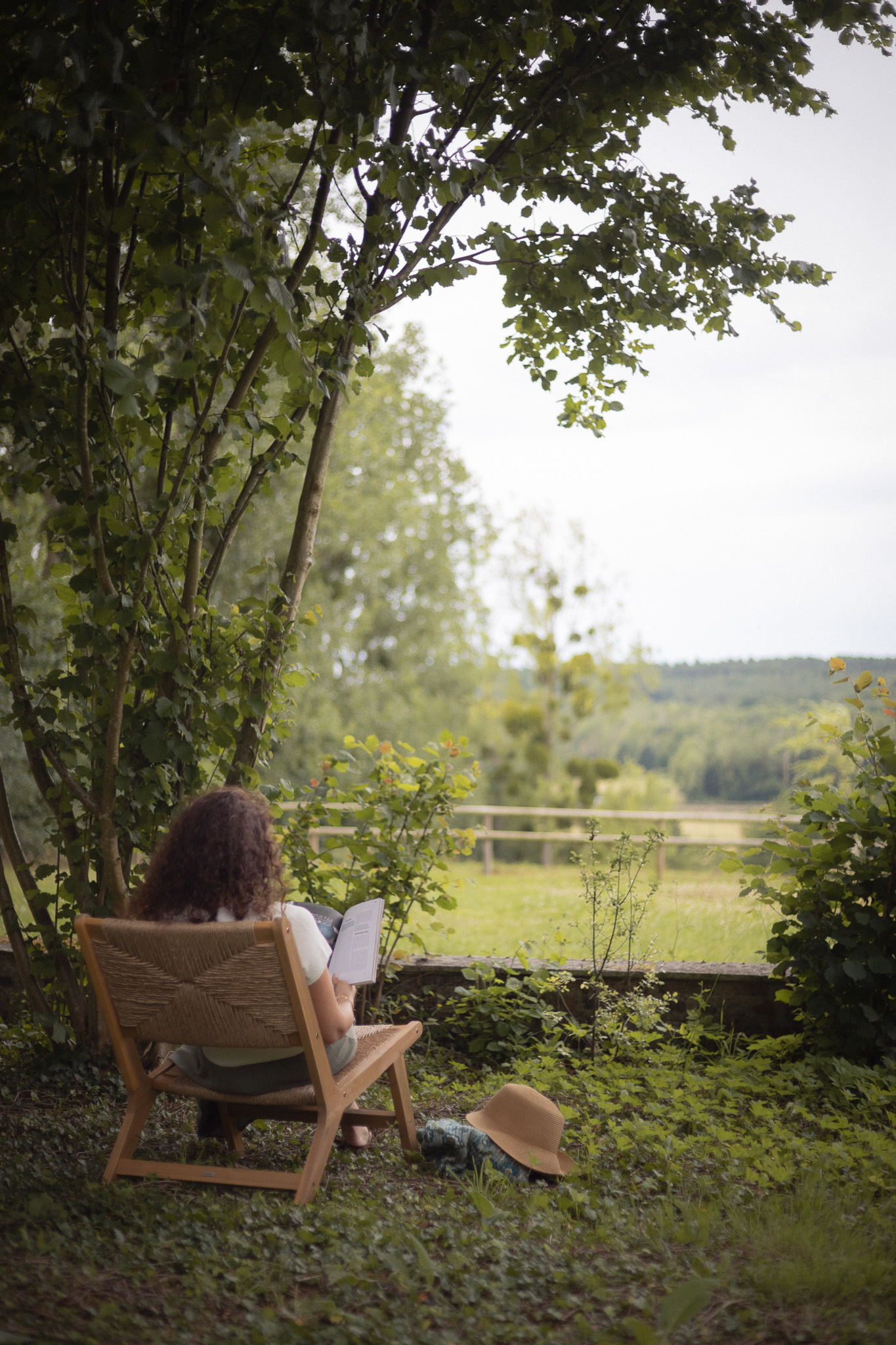 Chalet en pleine nature, avec une vue dégagée sur la verdure et une personne lisant.