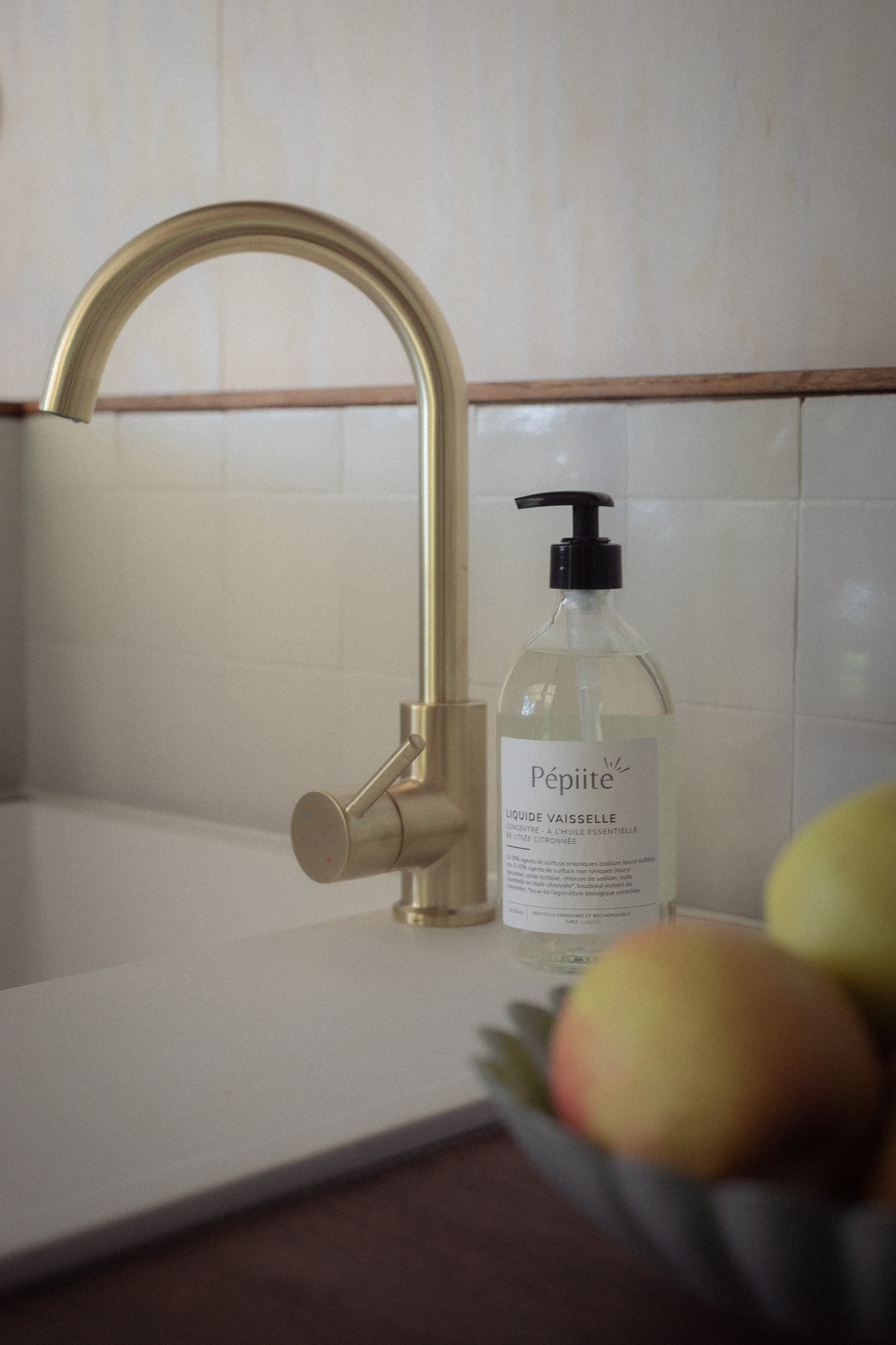 Élégante cuisine dun gîte, avec un robinet doré et des pommes fraîches.