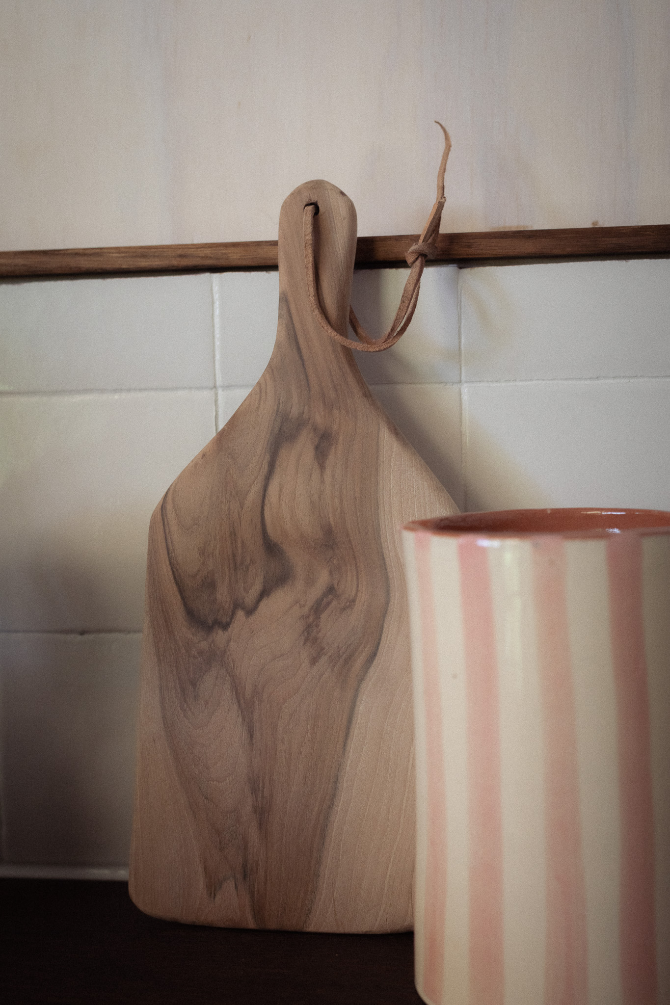 Planche en bois et tasse rayée dans un hébergement chaleureux et accueillant.