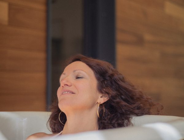 Bain relaxant dans un hébergement de luxe, ambiance chaleureuse en bois.