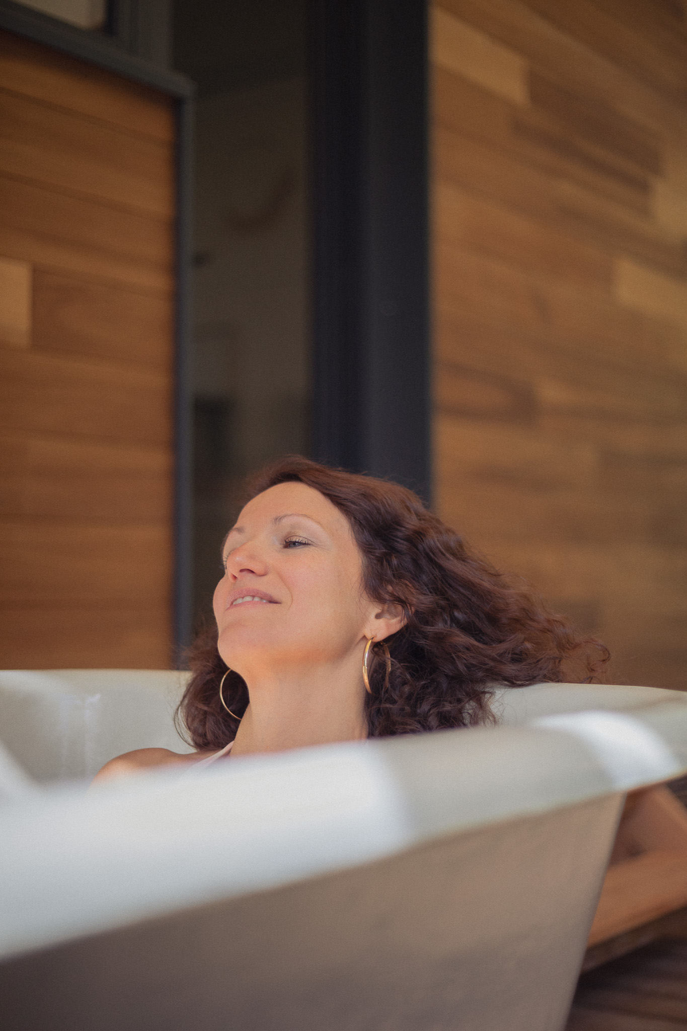 Bain relaxant dans un hébergement de luxe, ambiance chaleureuse en bois.