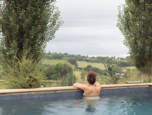 Hébergement de luxe avec piscine à débordement et vue panoramique sur la campagne.