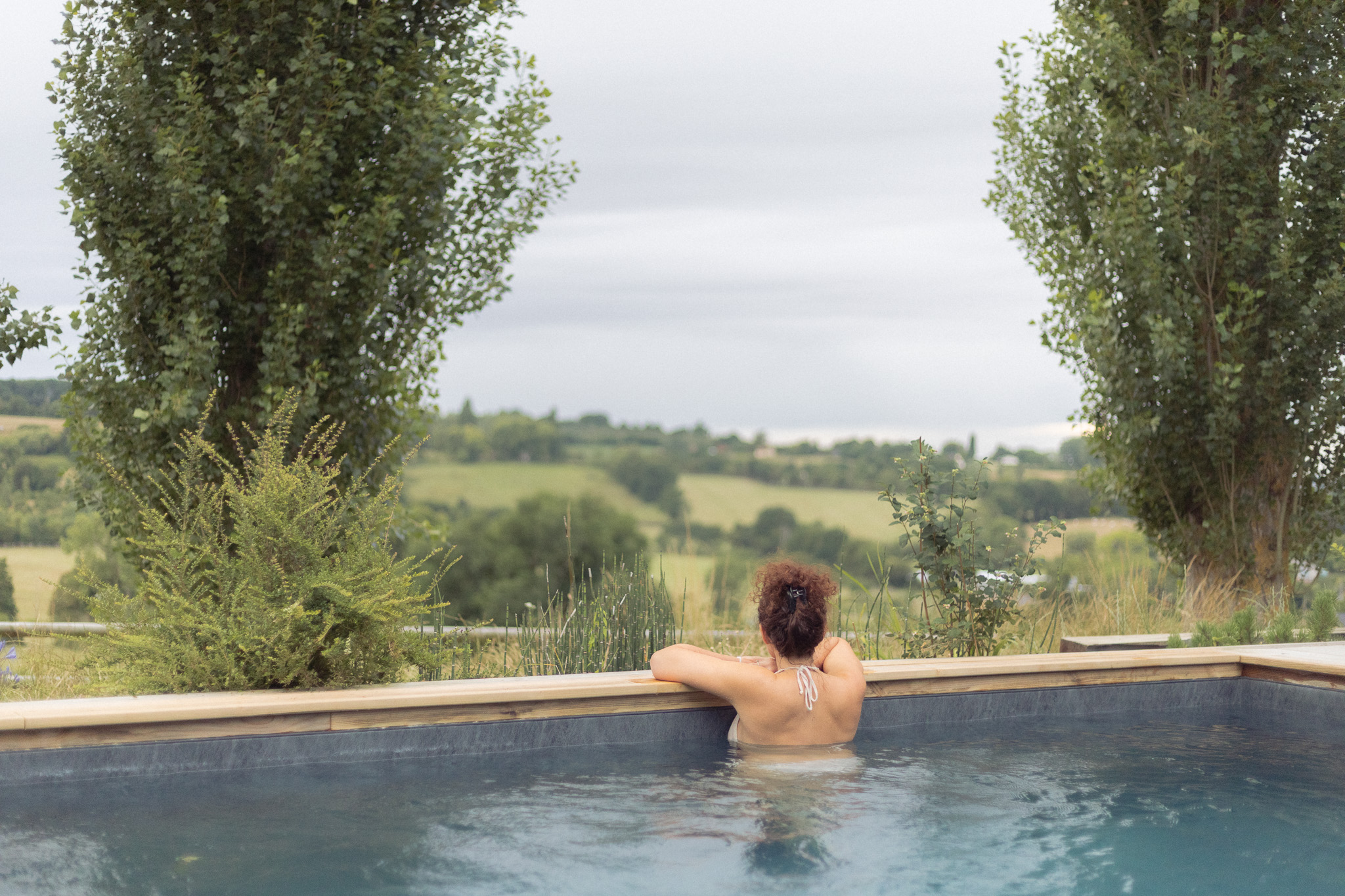 Hébergement de luxe avec piscine à débordement et vue panoramique sur la campagne.