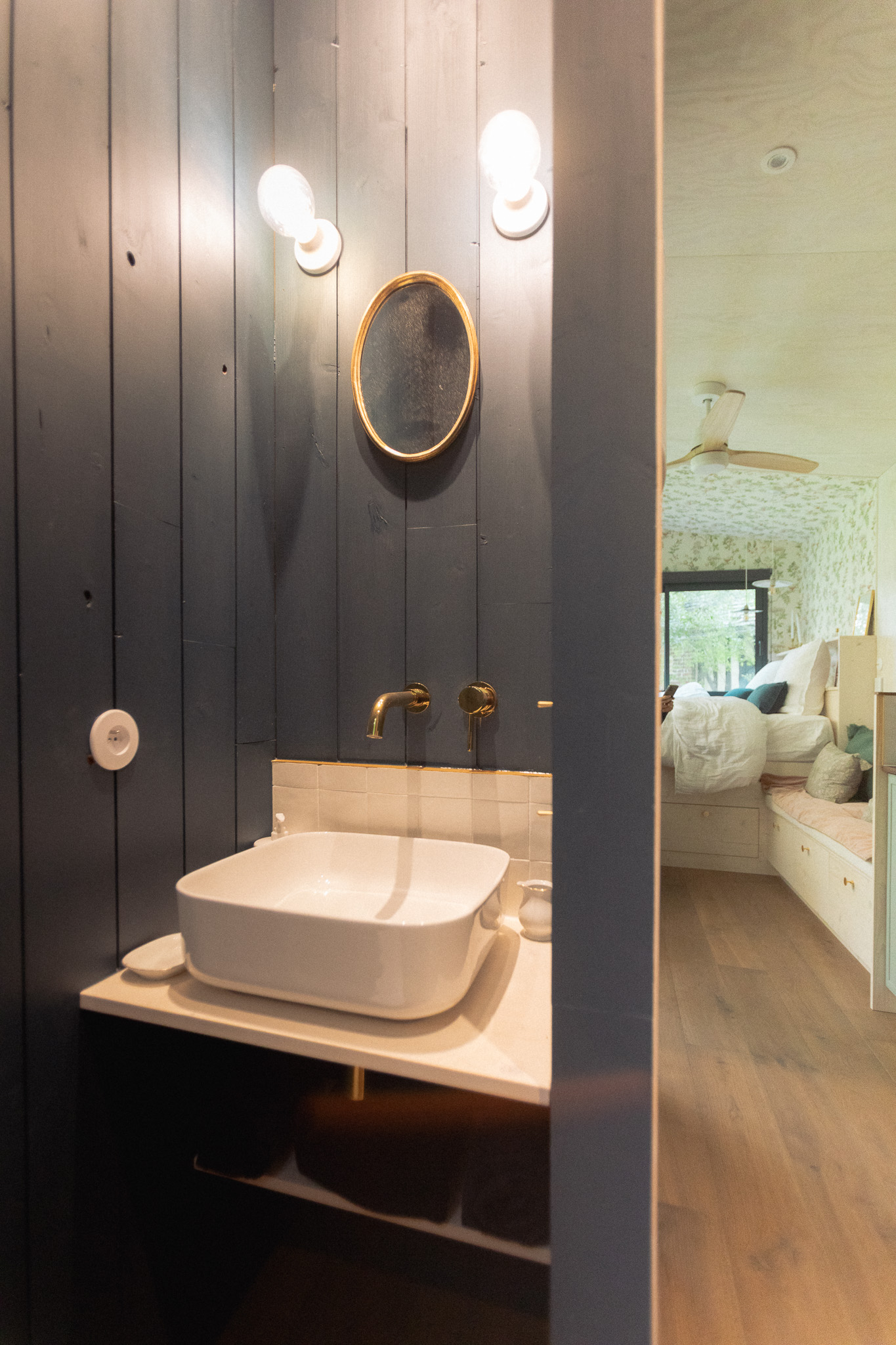 Salle de bain moderne dans un hébergement touristique, avec un lavabo élégant et des murs en bois.