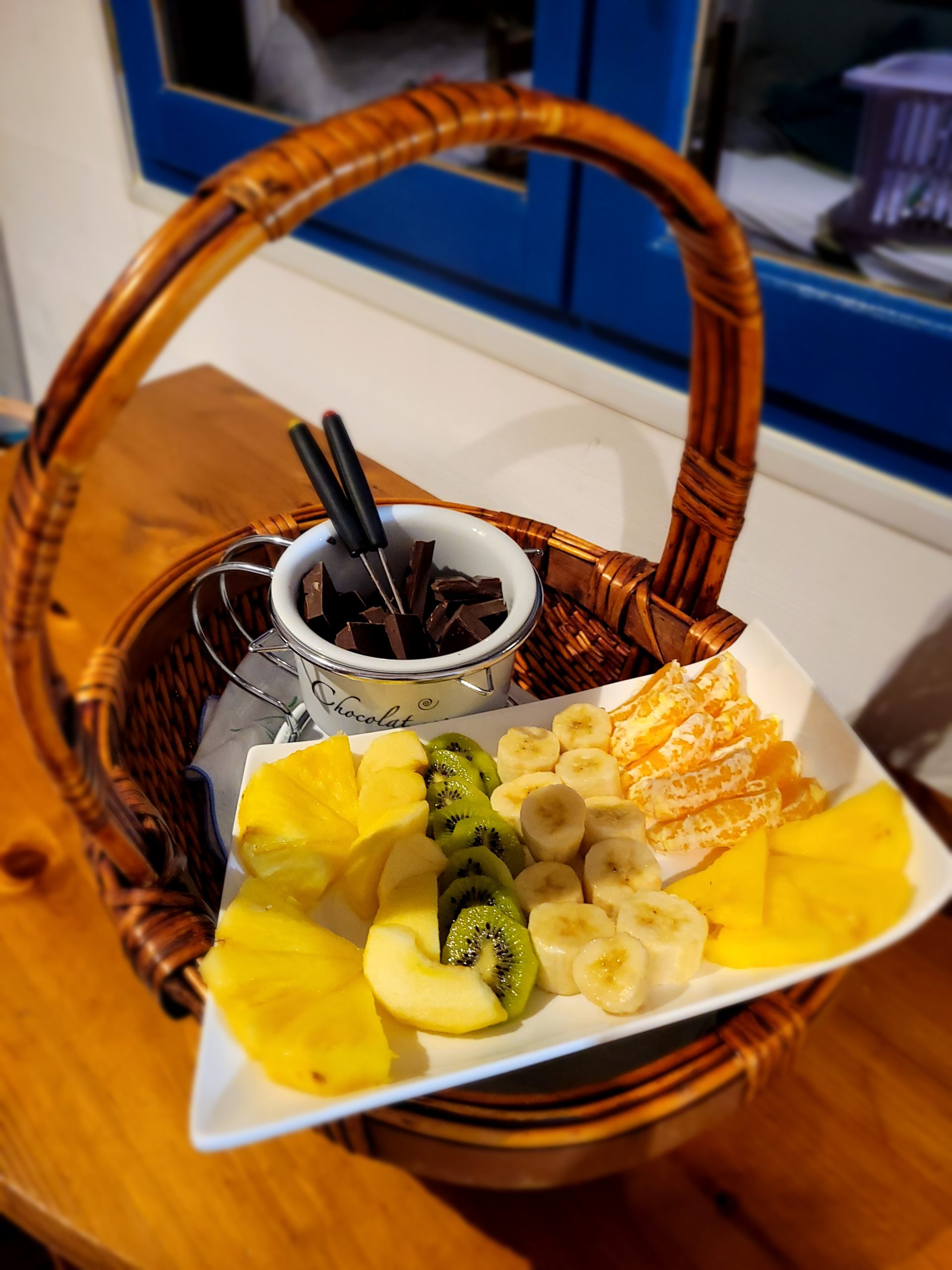 20240321_203055 Panier gourmand dans un hébergement insolite, rempli de fruits frais et chocolat.