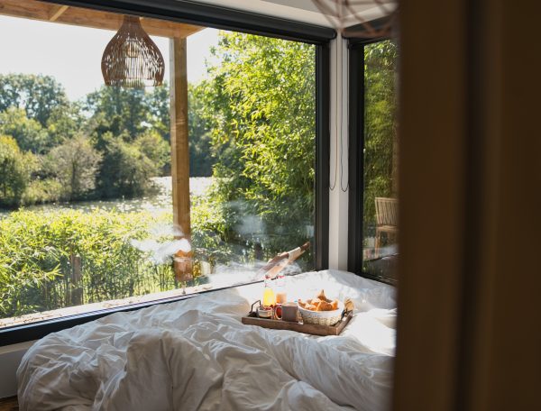 Chambre dhôtes moderne avec vue sur la nature et petit-déjeuner au lit.