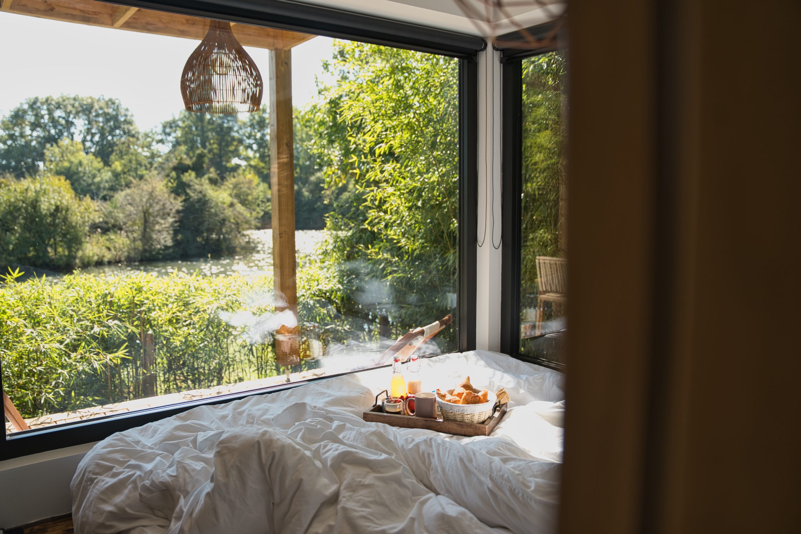 Chambre dhôtes moderne avec vue sur la nature et petit-déjeuner au lit.
