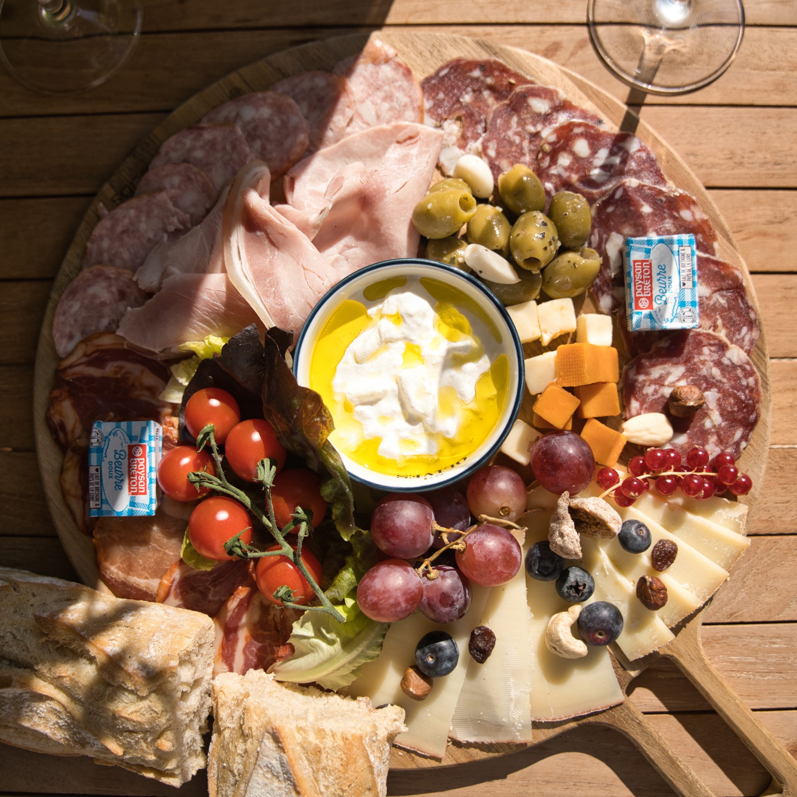 Plateau de charcuterie dans un gîte, avec fromages, olives et tomates cerises.