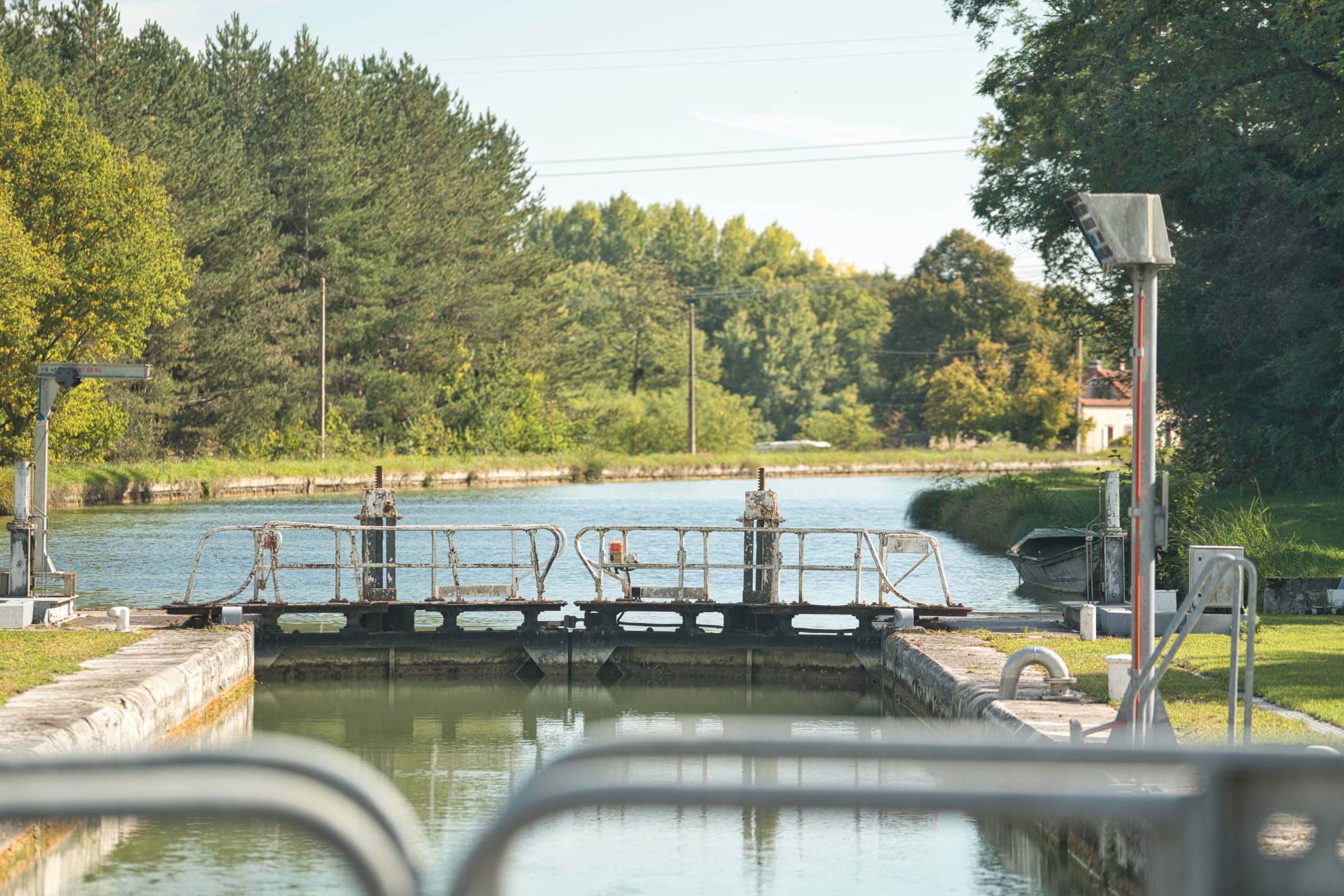 Écluse paisible au bord dun canal, entourée de verdure et de nature.