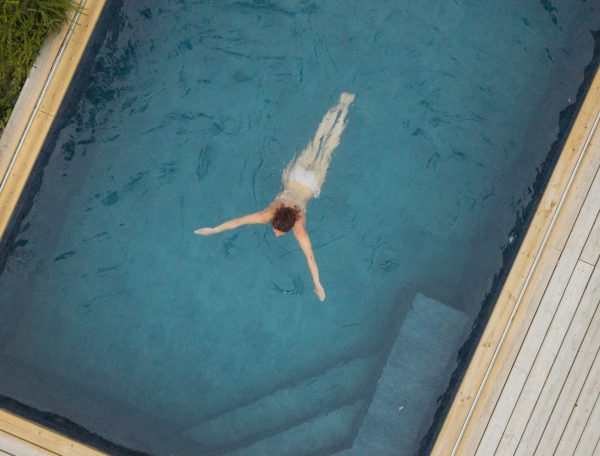 Hébergement avec piscine, un nageur se détend dans une eau cristalline.