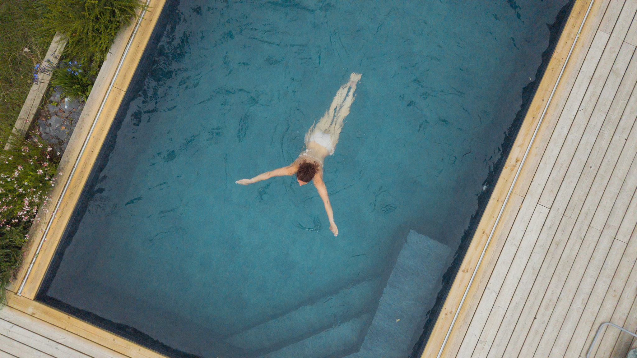 Hébergement avec piscine, un nageur se détend dans une eau cristalline.