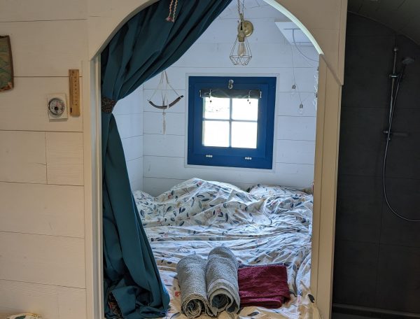 Chambre cocooning dans un hébergement romantique, décorée avec des draps fleuris.