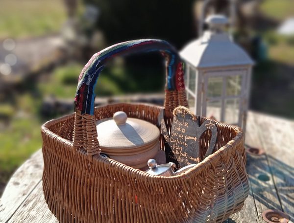 Panier en osier sur une table en bois, parfait pour un séjour en gîte rural.