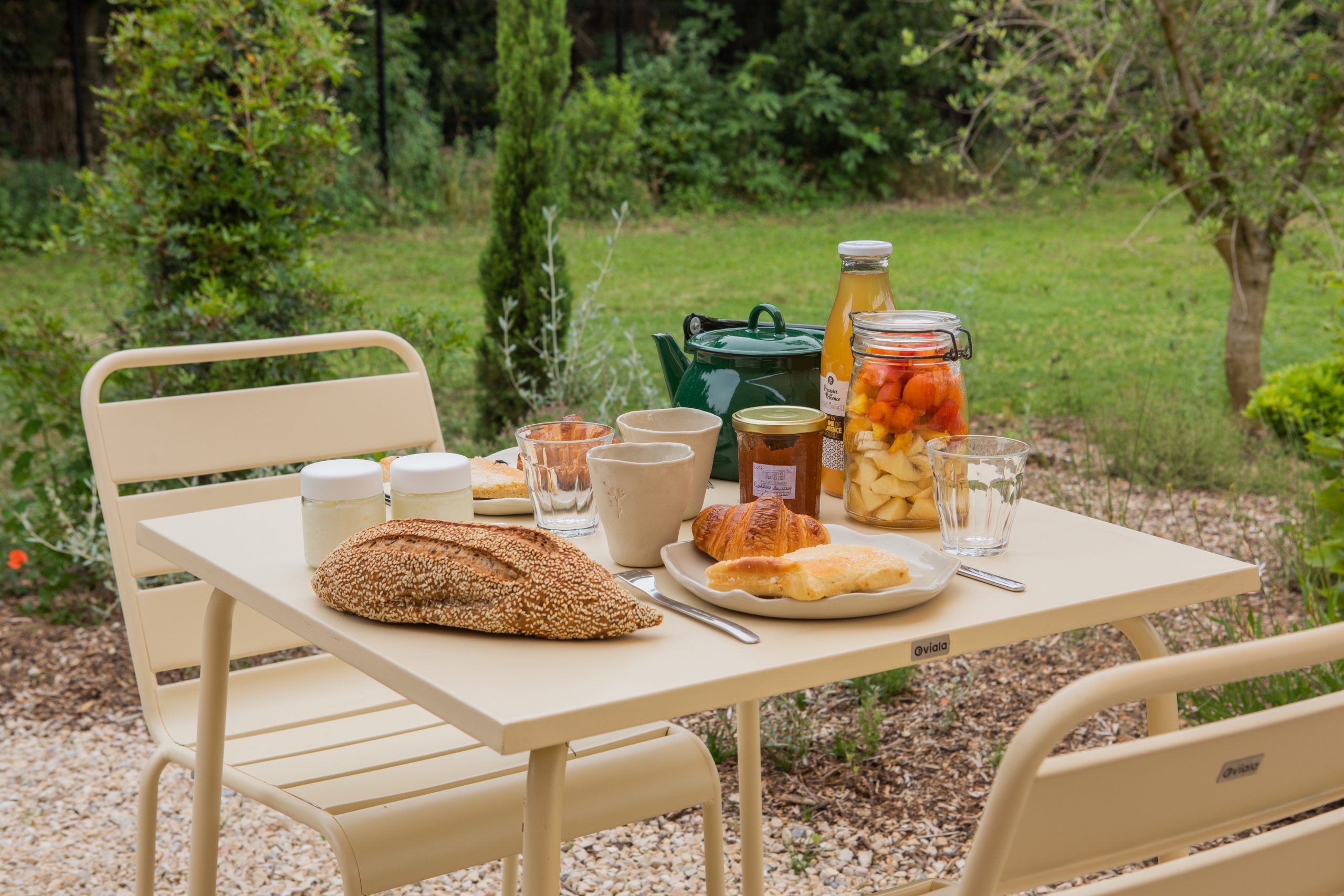 Tiny House-54 Table de petit-déjeuner en plein air, avec des mets variés et une vue sur la nature verdoyante.