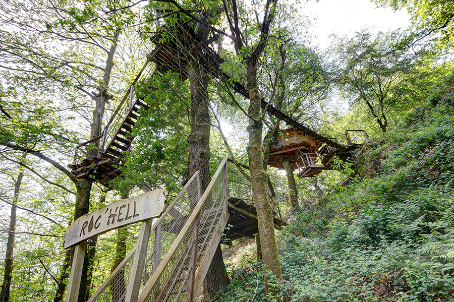 escapade-romantique-morbihan Cabane perchée dans les arbres, entourée de verdure, offrant une vue imprenable.