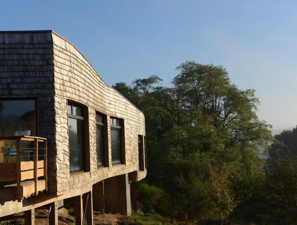Cabane en bois sur pilotis, avec vue dégagée sur la nature environnante.