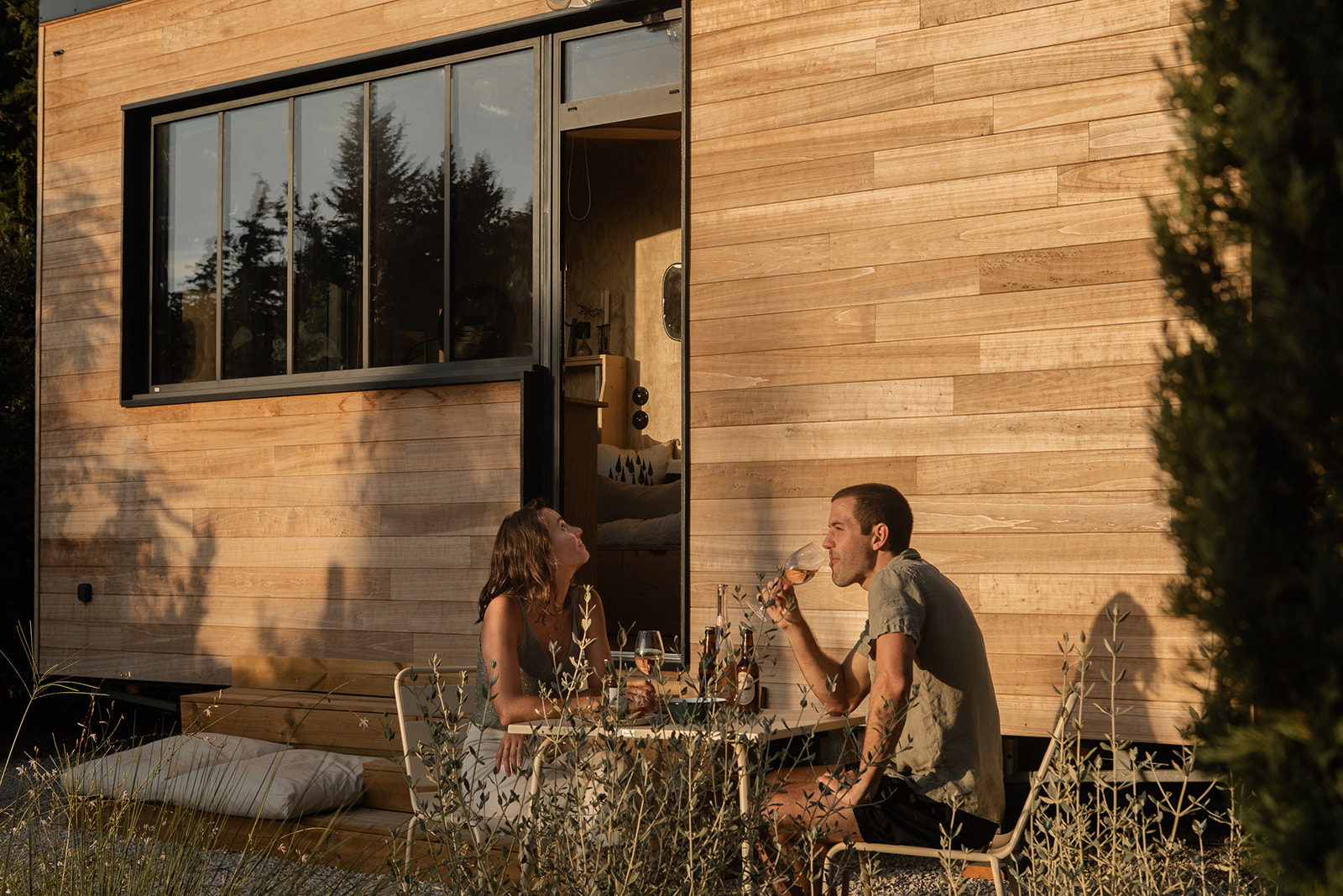 tiny-aout-72 Un chalet en bois moderne, avec une terrasse accueillante, parfait pour un moment convivial.